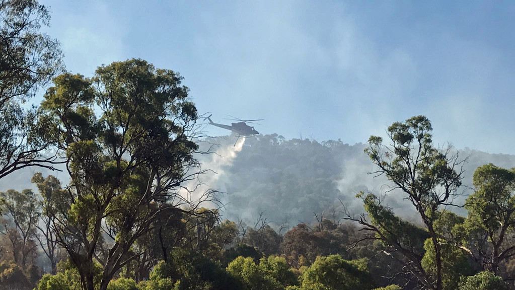 One of the ACT's water bombing helicopters drops water onto the fire at Booth. Photo by Steve Forbes.